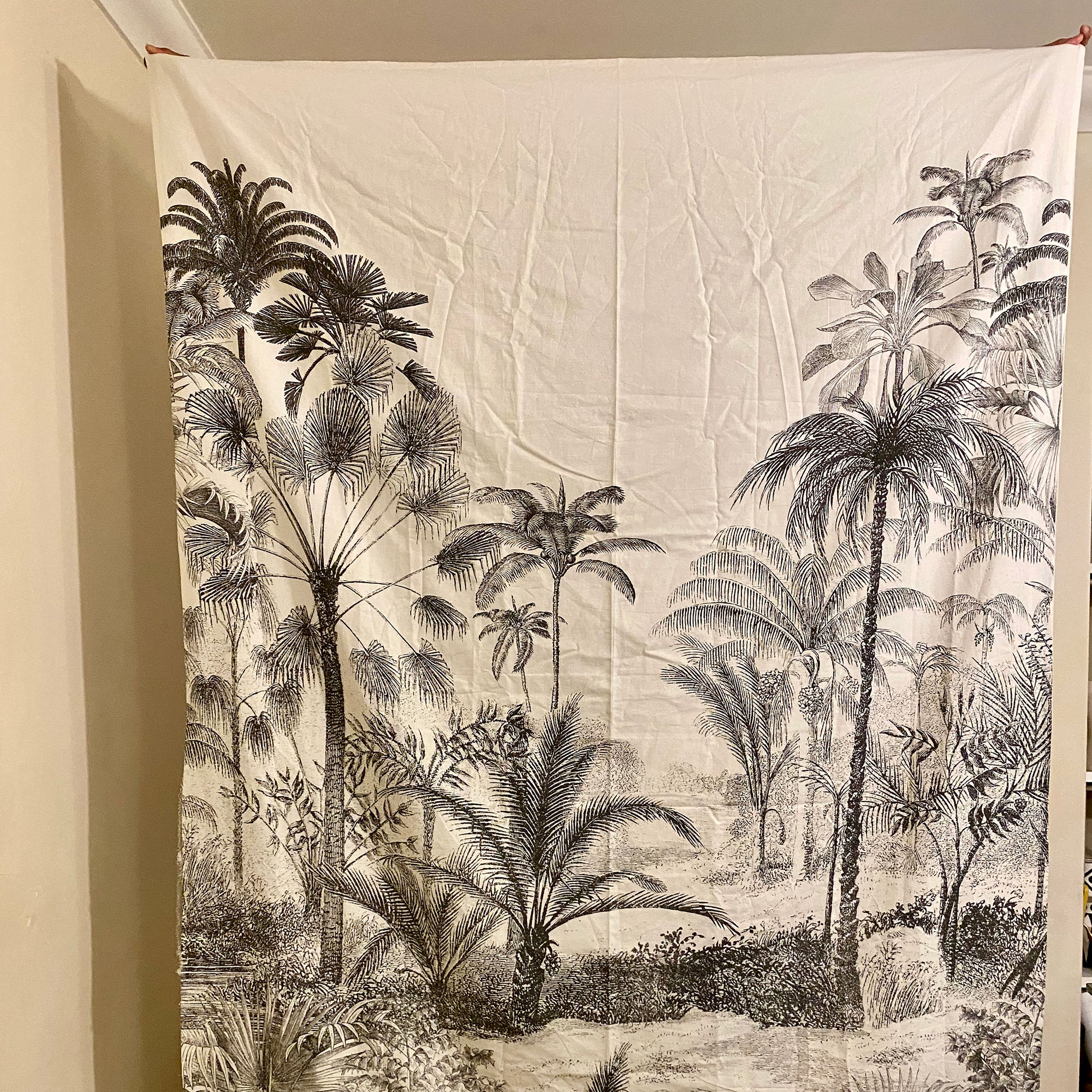 Person holding up monochrome tropical duvet cover