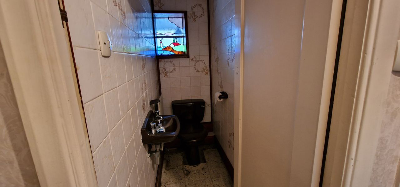 The toilet next to the bathroom is jet black