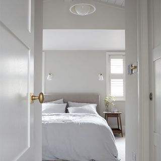 bedroom with white wall and white pillows on bed