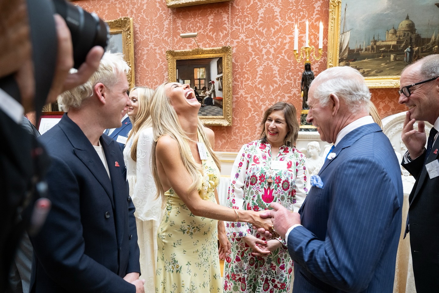 King Charles laughing with Sophie Habboo at a palace reception