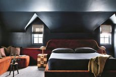 a dark blue bedroom with an oversized rust colored headboard