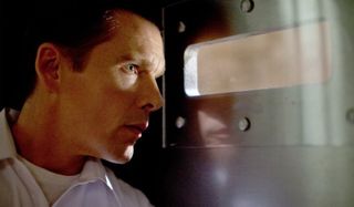 Ethan Hawke looks through a letterbox with anxiety in The Purge.