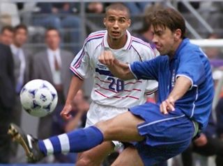Italy's Alessandro Costacurta kicks a ball under pressure from France's David Trezeguet in the team's quarter-final clash at the 1998 World Cup.