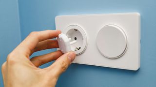 Man placing safety cover into an electric socket