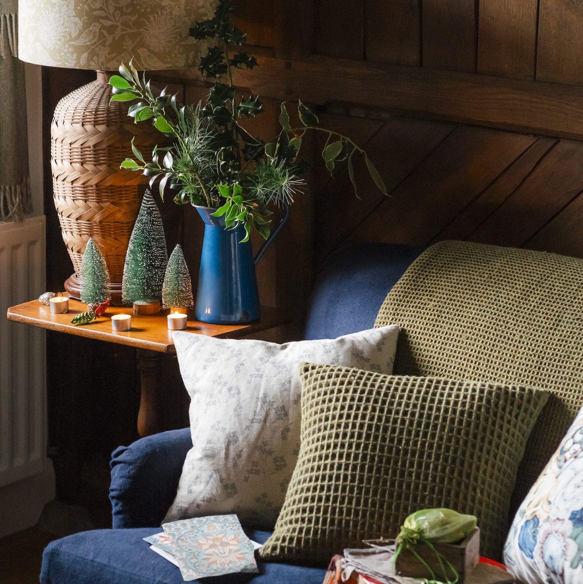 sitting room in coverted stables with wooden panel from stable stall and blue velvet sofa