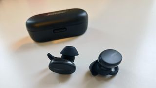 Bose Sport Earbuds review: the bud pictured next to their charging case