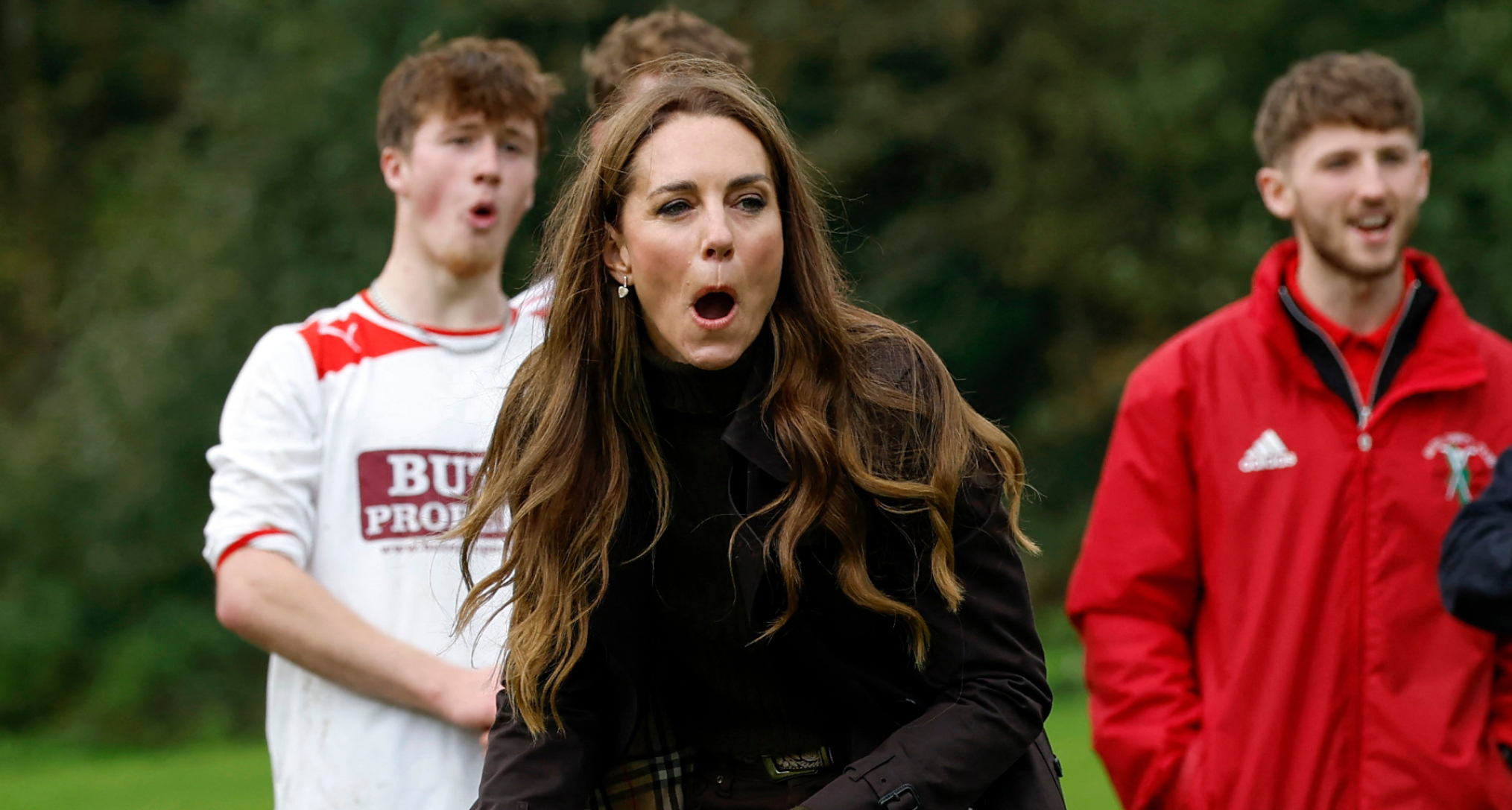 Princess Kate gasping playing shinty with two players behind her