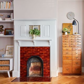 Living room open fireplace with tile surround next to vintage office drawers