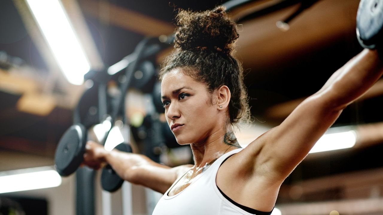 Woman performing dumbbell lateral raises