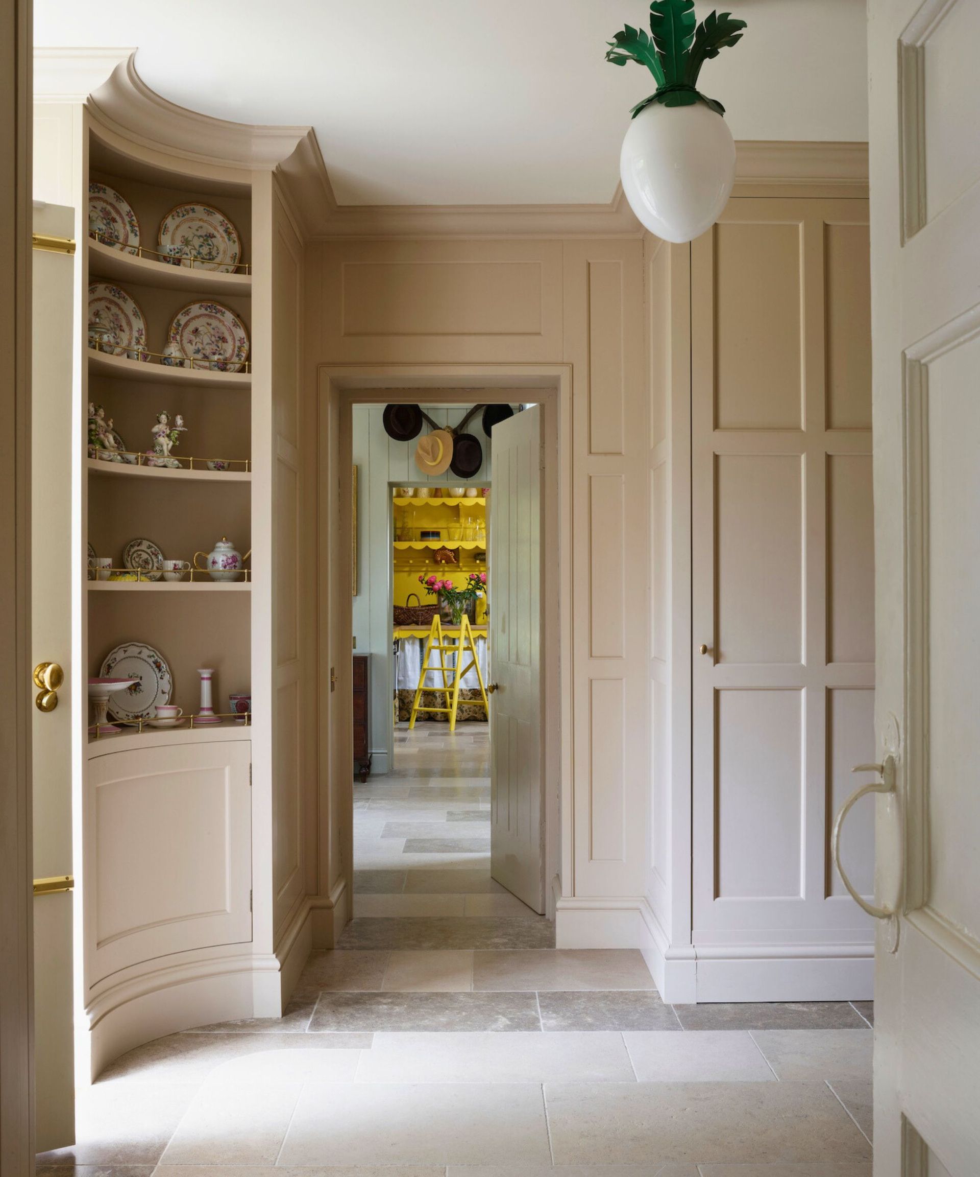 A cream galley pantry with a china cabinet