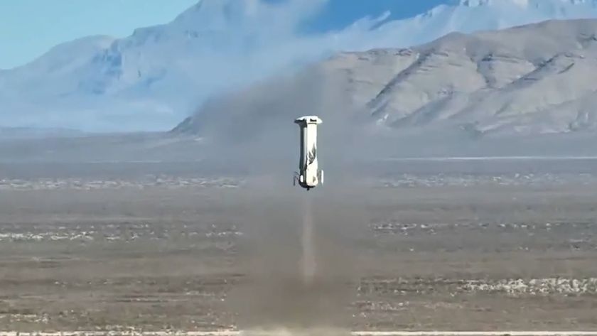 a white rocket lifts off above a desert full of scrub plants