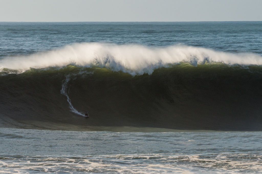 A surfer riding one of Nazaré&amp;#039;s giant waves 