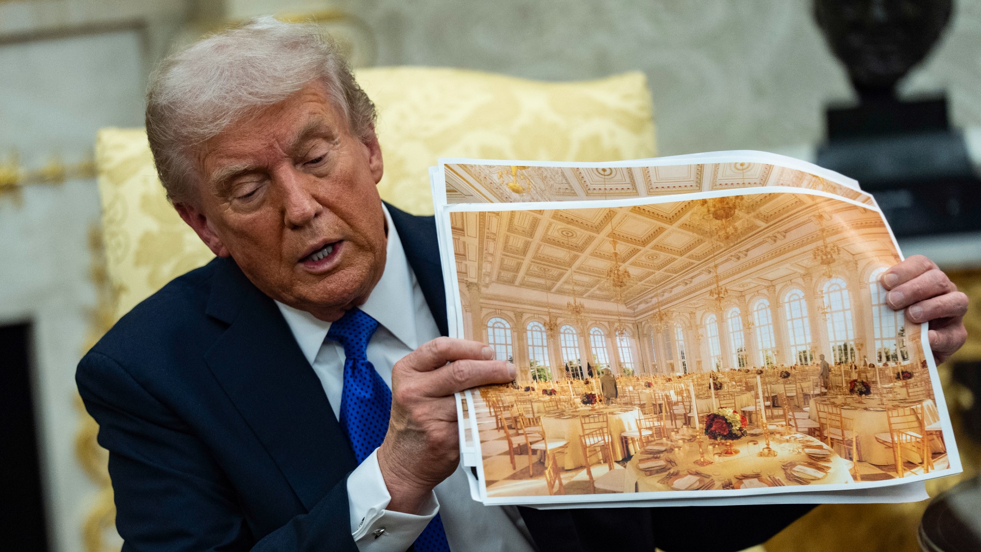 President Donald Trump speaks holding a photos of the new ballroom during a meeting with NATO Secretary General Mark Rutte in the Oval Office of the White House