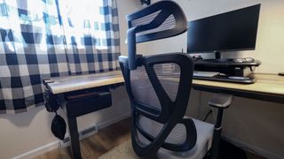 The ProtoArc EC100 office chair pushed into a desk