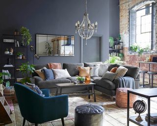 navy living room with large sofa, cushions and houseplants