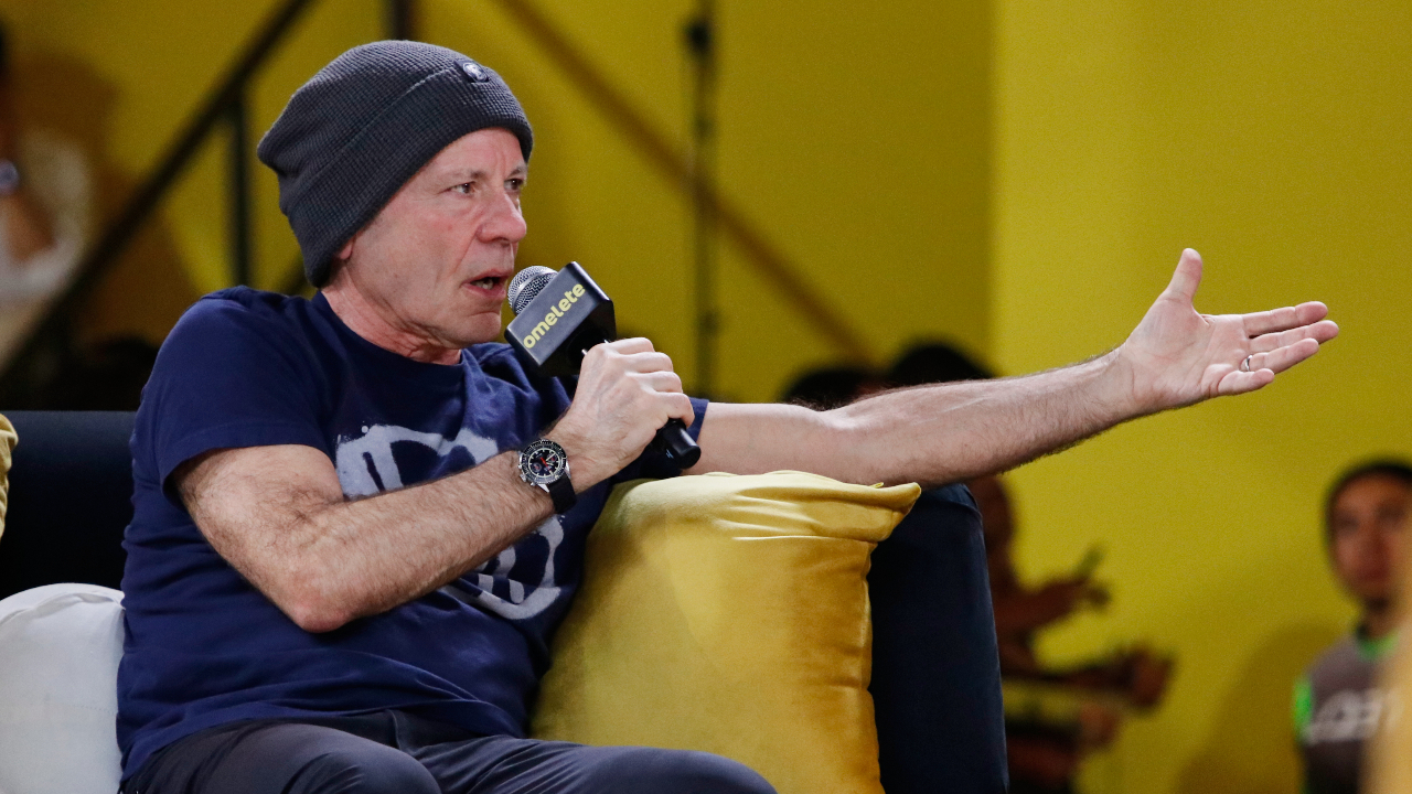 Bruce Dickinson sat on a sofa with a microphone
