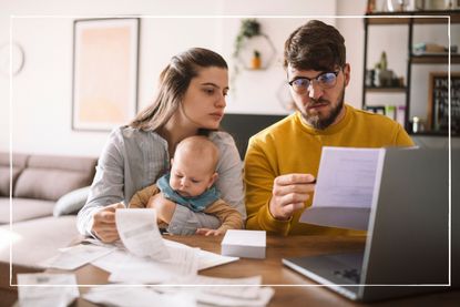 worried couple with a baby at home looking at bills