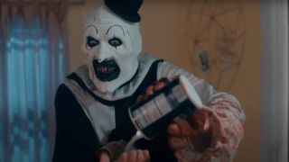 David Howard Thornton as Art the Clown pouring salt into his hand in Terrifier 2