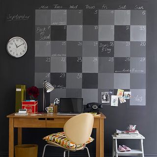 room with grey wall and and calender and desk