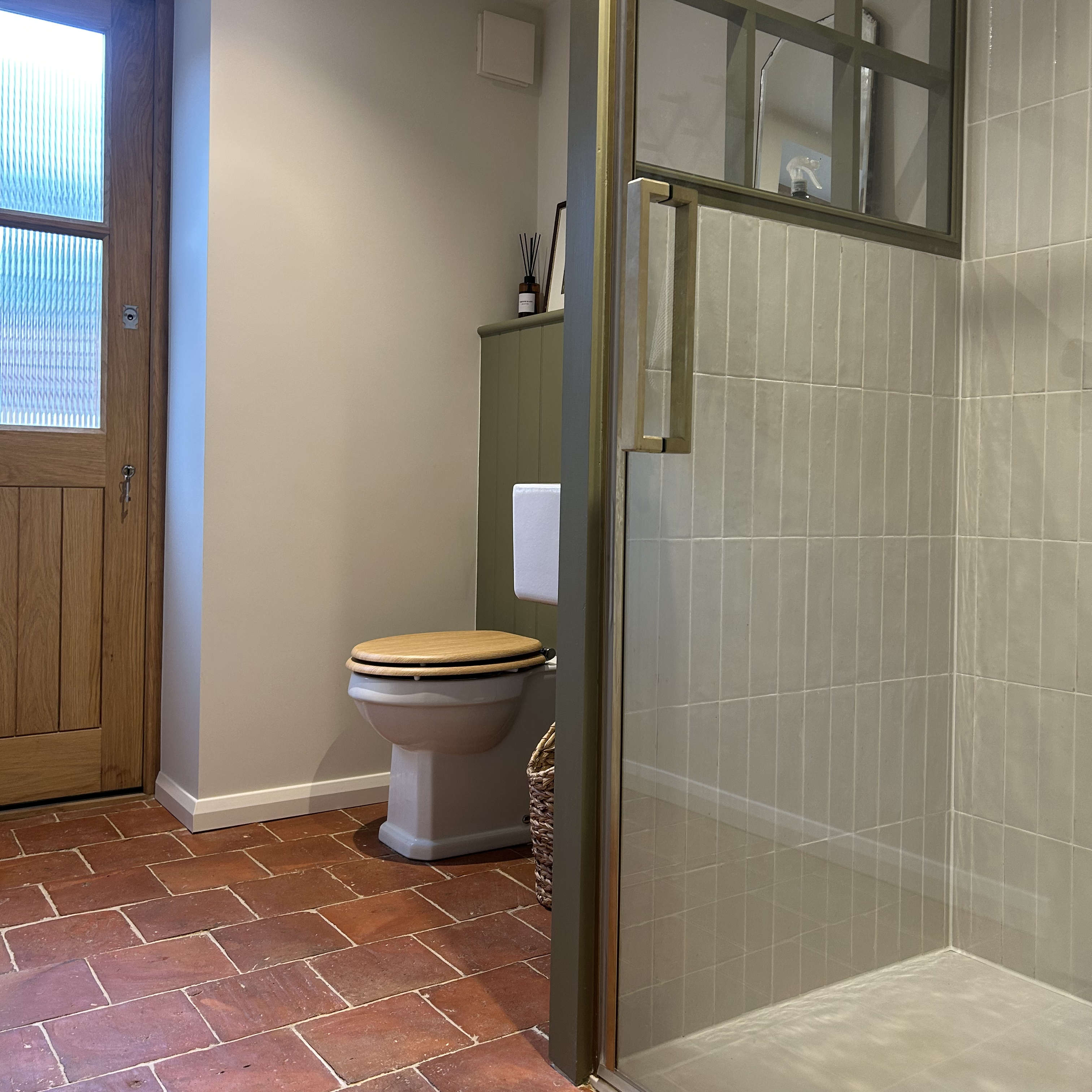 shower room with vintage-style toilet and red brick floor