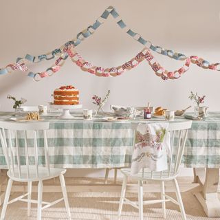 Blue and white table with selection of cakes and paper chains on wall