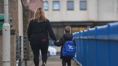 A woman walks child to school