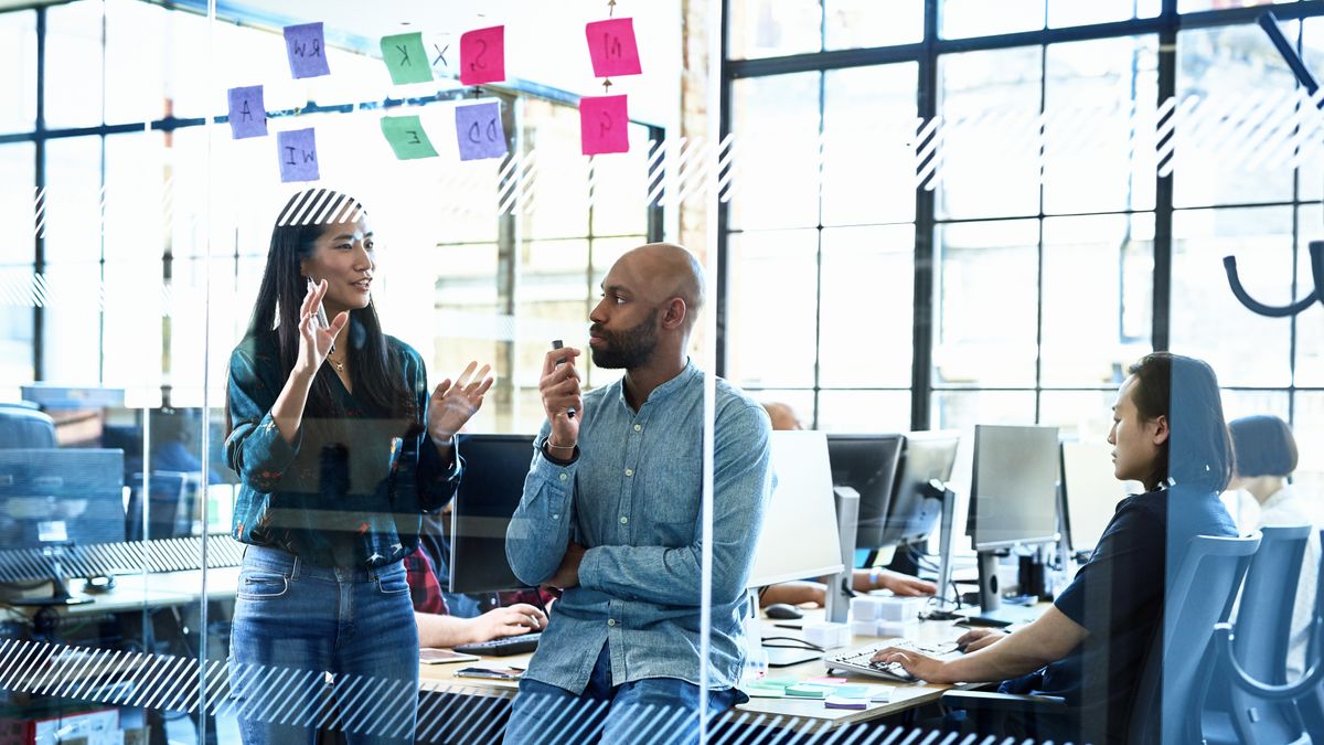 Team members meeting with post-it notes on a glass wall