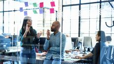 Team members meeting with post-it notes on a glass wall