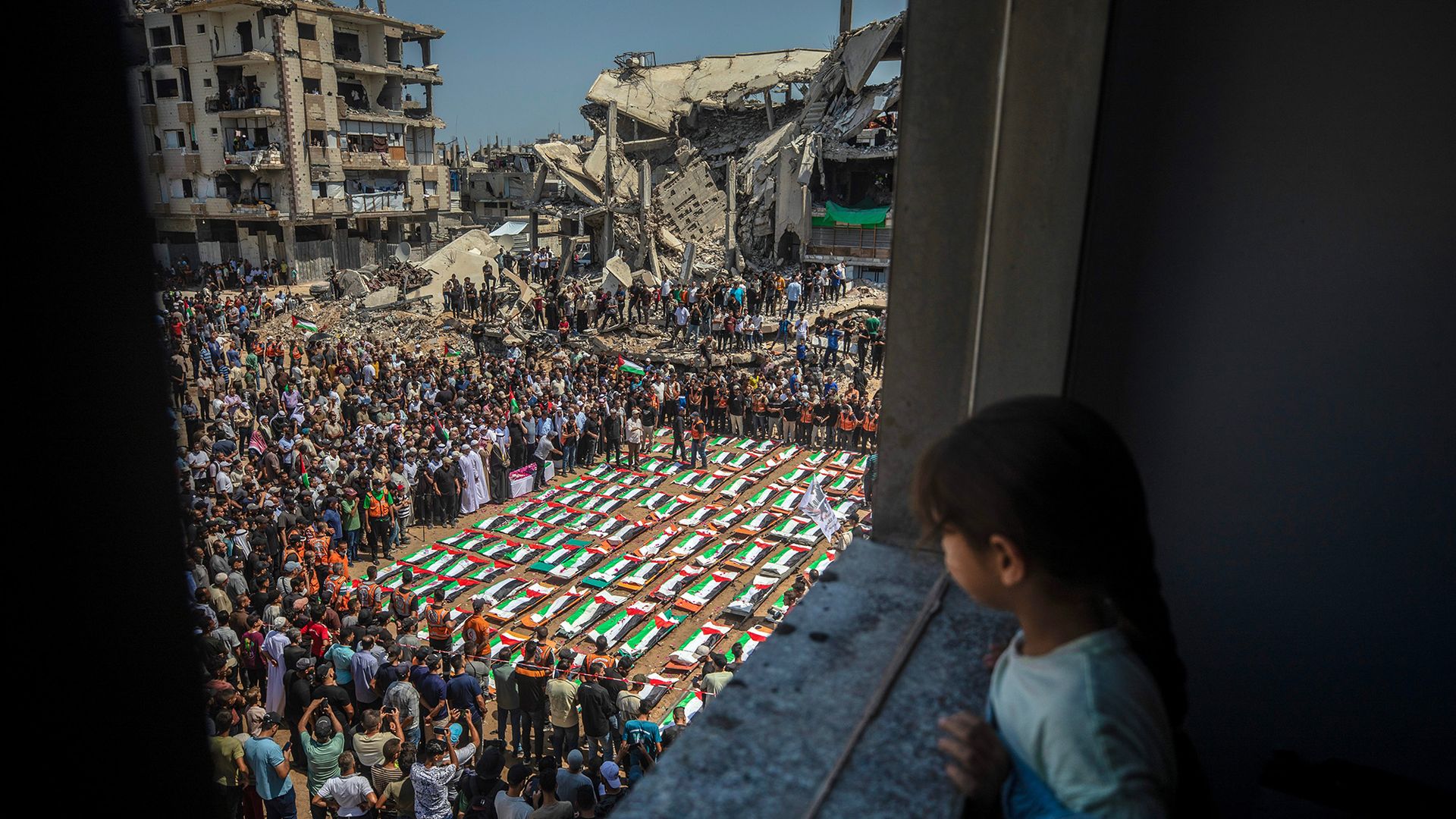 
                                A little girl watches on as Palestinians gather for a mass funeral for 112 members of the Abu Sharia and Al-Hasayna families in Gaza City, Palestine
                            