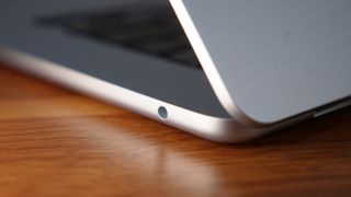 Close up photo of the right ports on a silver laptop, on top of a wooden surface.