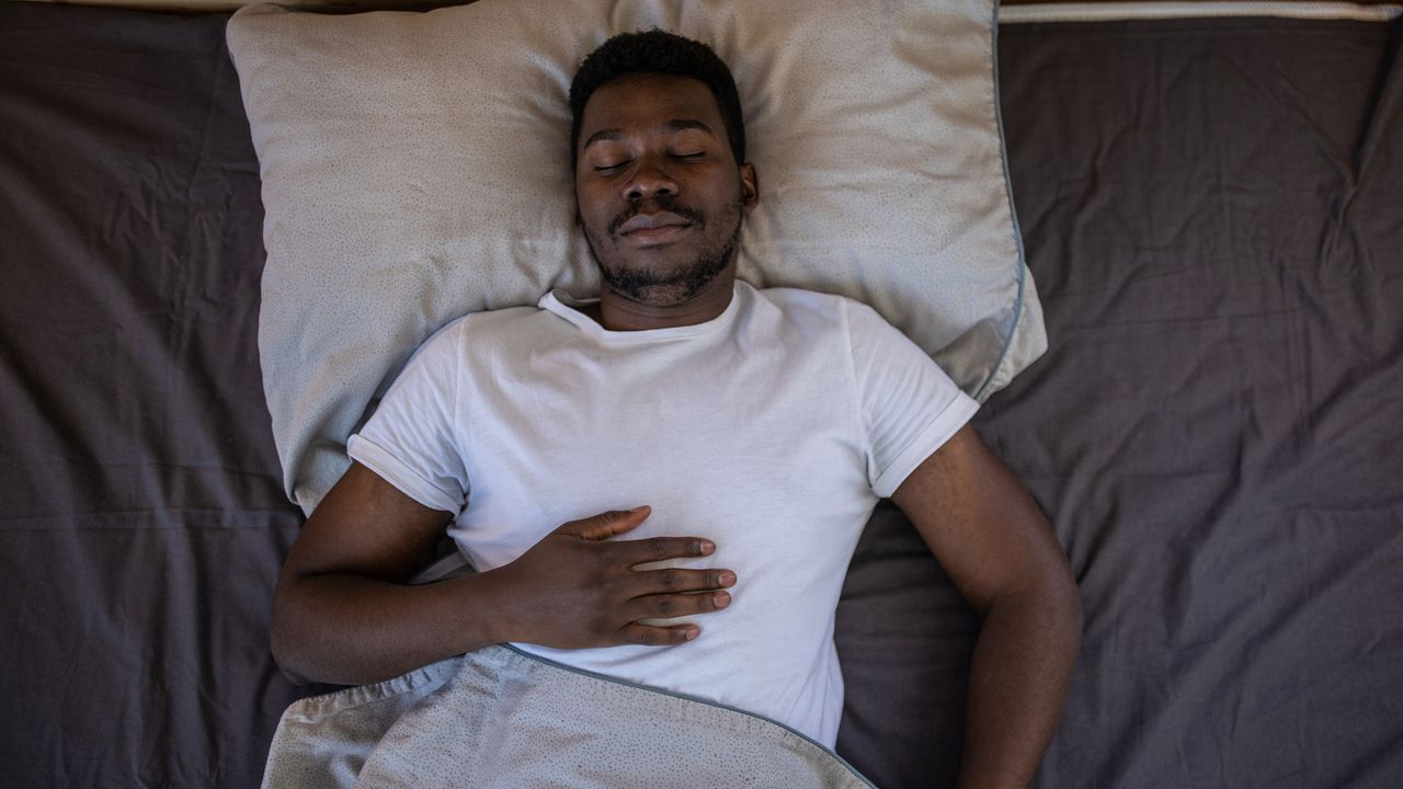 Man sleeping peacefully with his hand on his chest