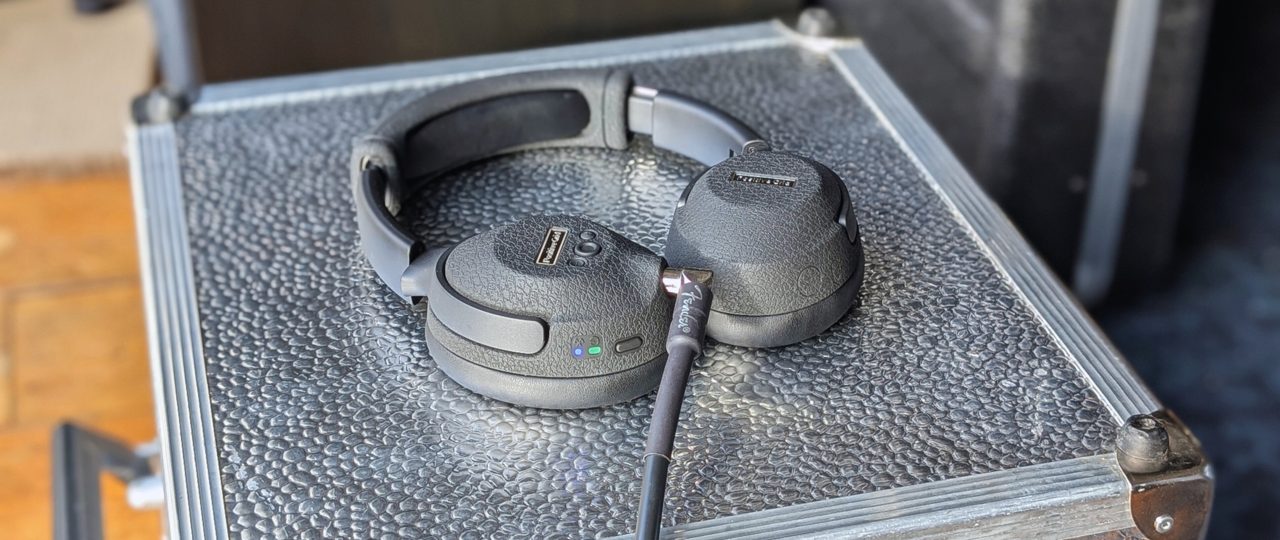 A pair of Positive Grid Spark Neo Core headphones on a silver flight case