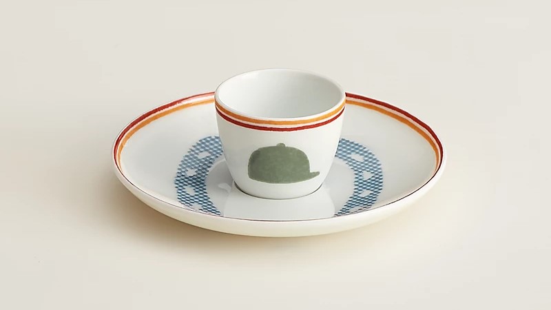 Hermès egg cup and saucer with riding hat and horseshoe motifs