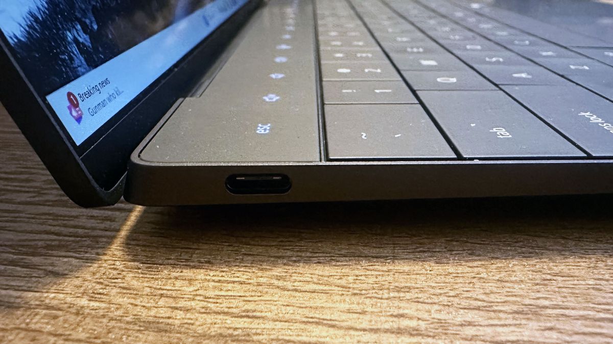 Close up of the USB-C port on a Dell XPS 13 (9350) on a wooden desk.
