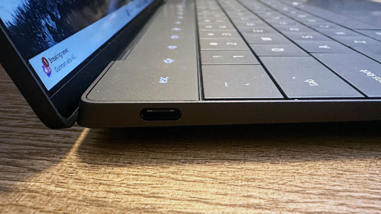 Close up of the USB-C port on a Dell XPS 13 (9350) on a wooden desk.