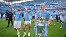 Man City striker Erling Haaland holds the Premier League trophy  