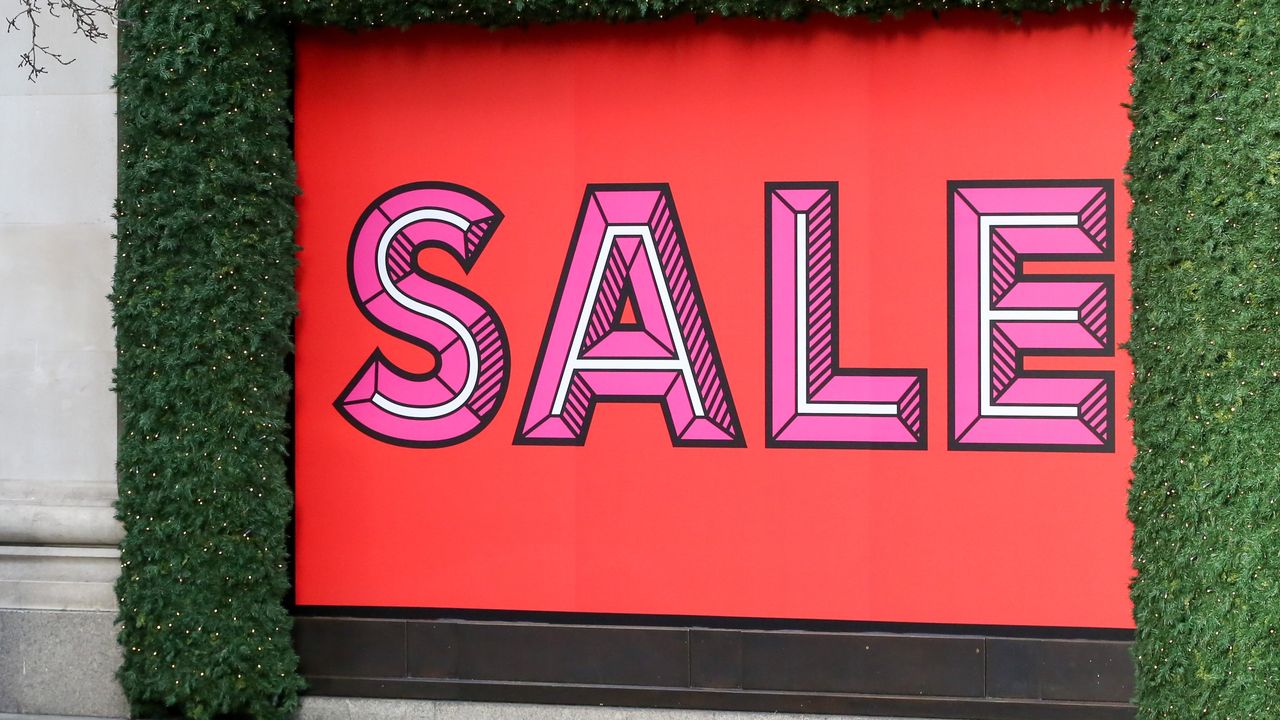 The store front of the London Selfridges store decorated for Christmas and with an entire window covered in a large red sale sign