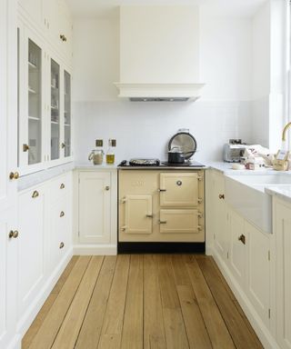 small creamy white kitchen with cream range cooker and wooden flooring