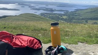Hydro Flask 32oz bottle on a rock with Loch Lomond in the background