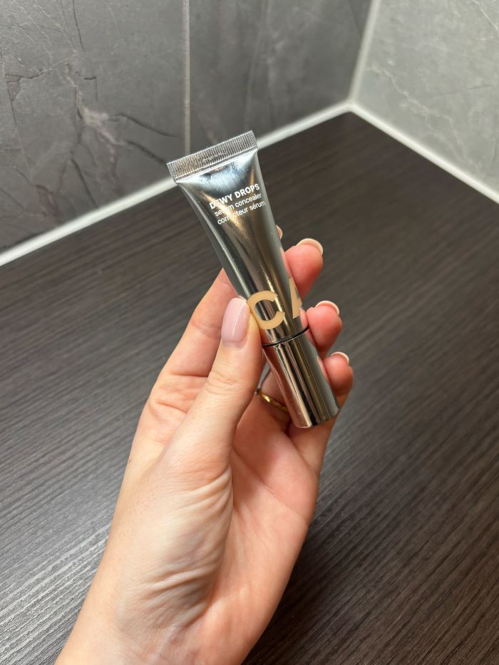 Deputy beauty editor Grace Lindsay holding a Caia concealer