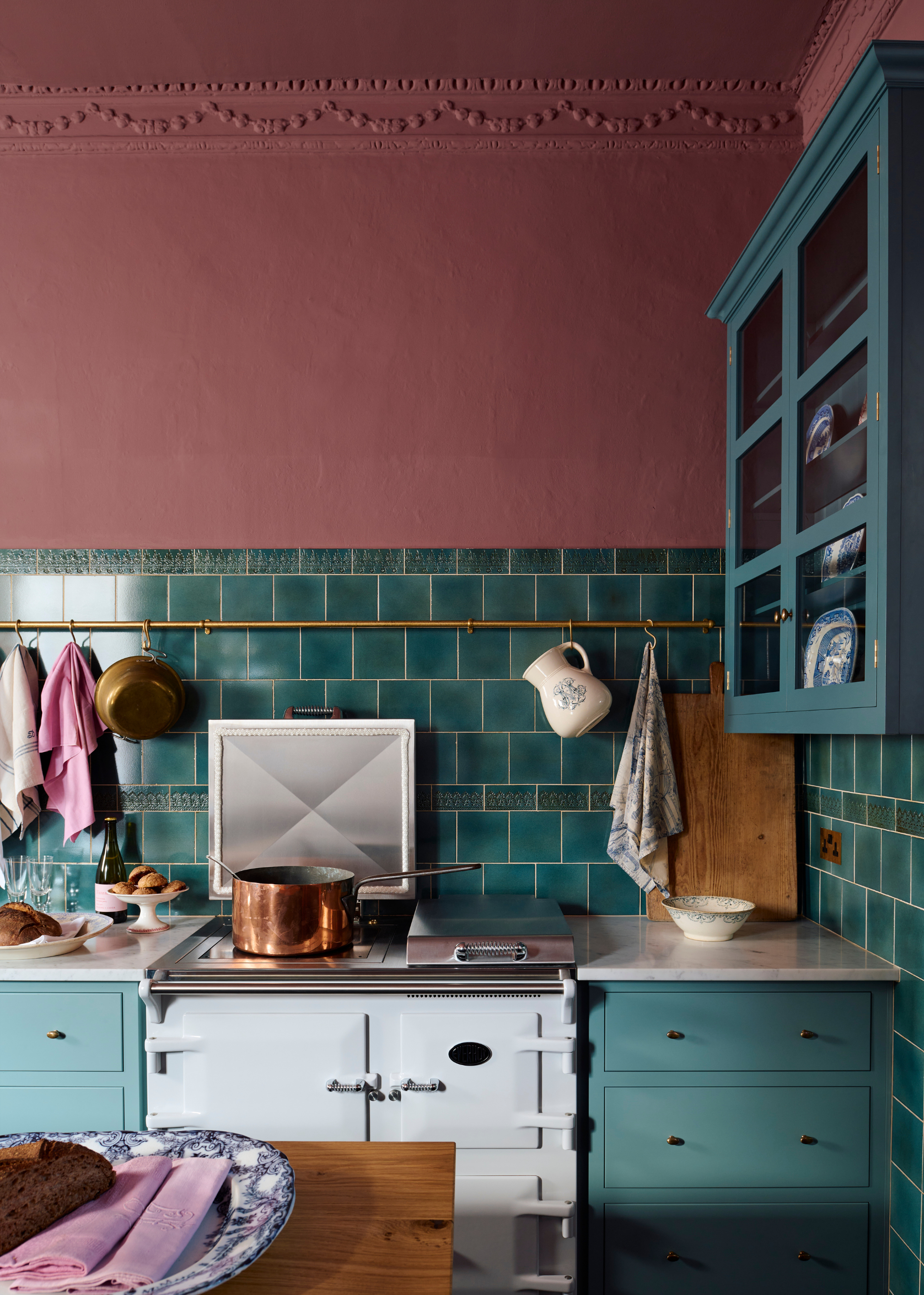 A pink and teal traditional kitchen where ceiling is painted pink too