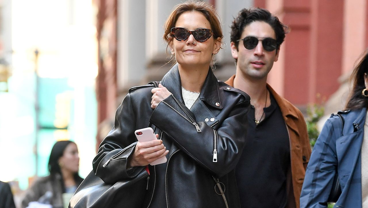 Katie Holmes walking in Soho wearing a leather biker jacket and a coordinating bag