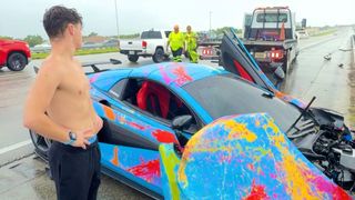 Influencer Jack Doherty stands next to the wreck of his McLaren sports car.