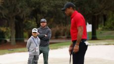 Graeme McDowell and his son watch Tiger Woods practice at the PNC Championship
