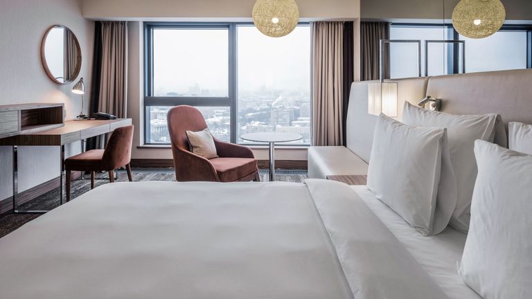 a luxury hotel room featuring plump hotel pillows on the bed