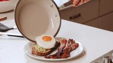 A Made In CeramiClad Pan, transferring an egg to avocado toast and bacon breakfast plate