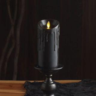 Wax Drip Flameless Pillar Candle - Black against a black background.