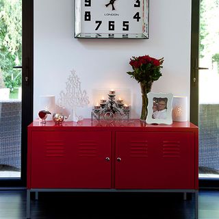 hallway with red cupboard and wall clock
