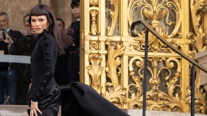 Zendaya wearing a long sleeve black dress with a long train to Schiaparelli Haute Couture show in Paris