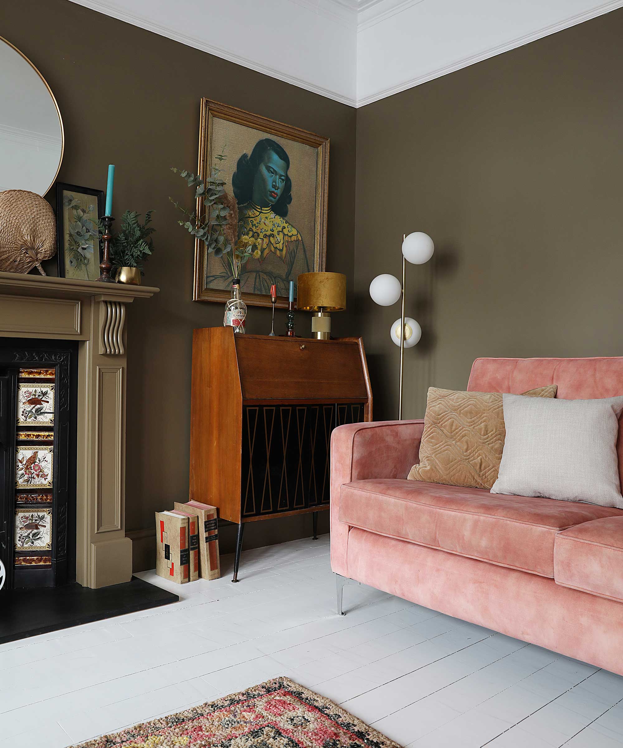 living room with olive painted walls and pale pink sofa